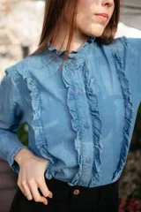 Camisa celeste de manga larga con cuello mao y volados en el frente.