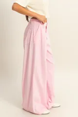 Pantalón palazzo color beige de tiro alto con pinzas y pierna ancha.