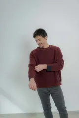 Sweater azul marino de hombre con cuello redondo y puños acanalados en color marrón.