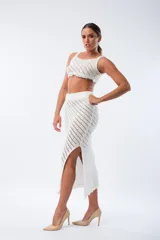 Pollera midi de tejido calado color blanco, con cintura elástica y abertura lateral.