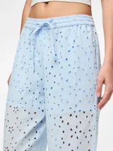 Pantalón celeste con broderie anglaise con cortes ovalados, cintura media y corte recto.
