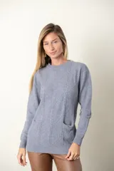 Sweater rojo de punto con cuello redondo y mangas largas. Presenta detalle de trenzado y distintos puntos en el frente, y dos bolsillos delanteros.
