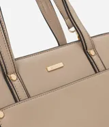 Cartera mediana color beige con paneles laterales de gamuza, doble asa de mano y correa larga desmontable.