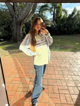 Camisa de manga larga con diseño patchwork a rayas horizontales en tonos celeste, naranja y verde. Tiene cuello clásico, bolsillo en el pecho y cierre con botones.