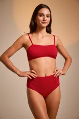 Top de bikini bandeau negro con textura brillante y tirantes finos ajustables.