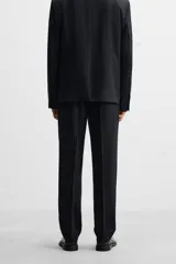 Pantalón de vestir negro slim fit confeccionado en tejido de lana de origen italiano. Cuenta con bolsillos frontales y traseros de vivo con botón. Cierre frontal con cremallera y botón. Colección especial Origins.