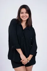 Camisa negra de corte amplio, con cuello clásico, cierre frontal con botones, manga larga con puños arremangados y bolsillo de parche en el pecho.