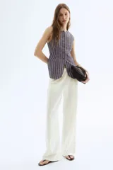 Pantalón blanco de lino con cintura elástica, bolsillos al bies y bolsillos traseros insertados. Piernas rectas con pliegue cosido adelante.