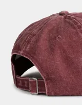 Gorra de béisbol color borgoña, confeccionada en denim con efecto lavado. Presenta bordado frontal con texto y regulador metálico trasero.