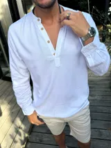 Camisola de lino blanca de manga larga con cuello mao y botones en el frente.