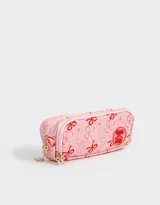 Cartuchera rosa claro con estampado de moños rojos y logo de cerezas. Tiene tres divisiones internas con cierre y tiracierre de moñitos.