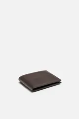 Billetera tipo cartera fabricada en piel color marrón oscuro. Cuenta con un compartimento para billetes, tres compartimentos para tarjetas, dos ranuras laterales y un monedero con cierre mediante clip.
