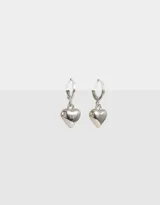 Aros argolla plateados con dije de corazón colgante.
