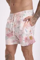 Short de baño con estampado de flores de loto y hojas en tonos amarillo, naranja y verde sobre fondo azul.