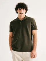 Camiseta tipo polo de manga corta, color verde oscuro, con cuello y tapeta de dos botones.