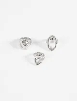 Set de tres anillos plateados de zinc con diferentes diseños bold.