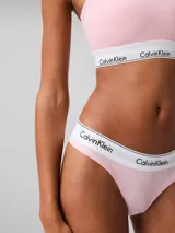 Conjunto de ropa interior Calvin Klein, compuesto por un corpiño bandeau y una bombacha colaless, ambos en color rosa claro con banda elástica blanca con el logo de la marca.