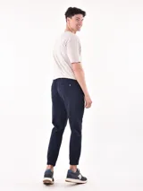 Pantalón jogger gris oscuro con cintura elástica ajustable con cordón y puños elásticos en los tobillos.
