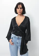 Camisa de seda negra con tiras para anudar en el frente, de manga larga y escote profundo.
