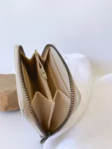 Billetera pequeña color peltre con textura croco, cierre metálico y monedero interno.