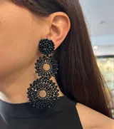 Aros colgantes largos con forma de círculos tramados con cuentas de cristal color turquesa.