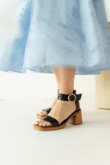 Sandalias de cuero color crudo, con tira ancha sobre los dedos, pulsera con hebilla al tobillo y taco cuadrado de madera.