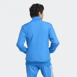 Campera Adidas del Real Madrid, modelo Terrace Icons, color celeste con detalles en blanco. Presenta cierre frontal, cuello alto, bolsillos frontales y escudo bordado del Real Madrid.