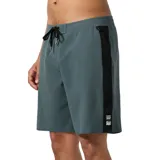 Boardshort de surf de 19 pulgadas, color verde azulado oscuro, con franja vertical negra en el lateral y cordón de ajuste negro en la cintura. Presenta un pequeño parche con el logo de la marca en la parte inferior del lateral derecho.