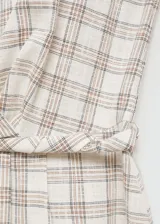 Vestido midi sin mangas, con estampado de cuadros en tonos beige y marrón. Presenta escote redondo y corte evasé.