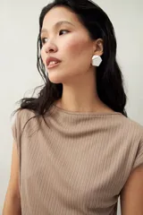 Top color beige de tejido acanalado, con cuello recto, sin mangas y terminación asimétrica en pico.
