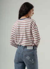 Camiseta de manga larga, corte holgado, con cuello redondo y estampado de rayas horizontales en tonos negro y marrón.