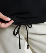 Polera hecha en tela canalé con tacto peluche, color ladrillo, con cuello alto, mangas largas y lazo en el bajo.