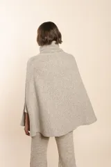 Capa marrón de lana con cuello alto abotonado y aberturas laterales.