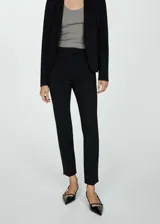 Pantalón negro de vestir, de corte recto, con cierre de cremallera y gancho, tiro medio, trabillas y bolsillos laterales y traseros.