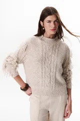 Sweater color beige de tejido de punto con cuello redondo y mangas largas con flecos.