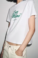 Camiseta blanca de algodón con cuello redondo y mangas cortas. Estampado frontal con la frase "Paris, Mon doux rêve!" en azul marino.