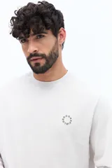 Remera de manga larga color negro, con escote redondo y un pequeño logo circular estampado en el pecho.