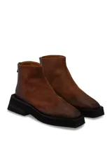 Bota de cuero negro con diseño estilizado y suela gruesa.