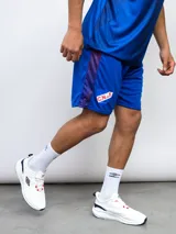 Short deportivo azul marino con laterales estampados con el escudo del Club Nacional de Football.