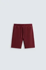 Bermuda negra de corte relaxed fit, con cintura elástica ajustable con cordón, bolsillos frontales y bolsillo trasero de parche.