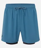 Bermuda deportiva azul con short de compresión interno, cintura elástica con cordón ajustable y bolsillo trasero con cierre.