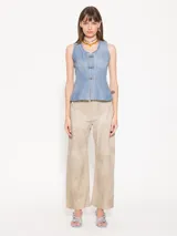 Pantalón ancho de cuero ovino color beige, con recortes verticales y horizontales, bolsillos delanteros tipo jean y bolsillos traseros tipo parche.