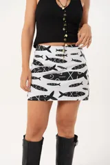 Minifalda blanca con estampado de peces negros, de silueta recta.