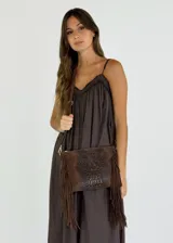 Bandolera de cuero marrón con textura tipo piel de cocodrilo y flecos de gamuza en los laterales.