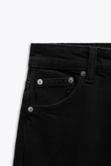 Pantalón de jean negro de tiro alto, corte skinny y cinco bolsillos.