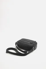 Bandolera negra de acabado engomado con correa ajustable y extraíble. Tiene un compartimento principal con cierre de cremallera, un bolsillo interior con cremallera y un bolsillo frontal con cremallera.