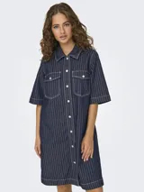 Vestido camisero midi de denim azul con rayas verticales blancas, cuello camisero, mangas 3/4, cierre frontal con botones y dos bolsillos de parche en el pecho.