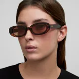 Lentes de sol modelo Lua con montura ovalada y estilizada de diseño retro. Presentan un marco con patrón de carey en tonos marrones y lentes polarizadas de color marrón con protección UV400.