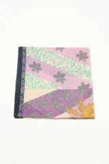 Pareo rectangular de algodón con estampado de margaritas en tonos beige, amarillo, celeste y lila.