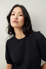 Remera negra de algodón con mangas abullonadas y elástico en la terminación.